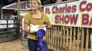 Girl holding a chicken at a fair